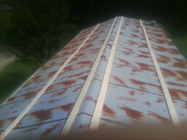 Rusted metal roof panels with new wood purlins before replacement — Storm Damage Roof Repair in Heath Springs by Roofing Brothers