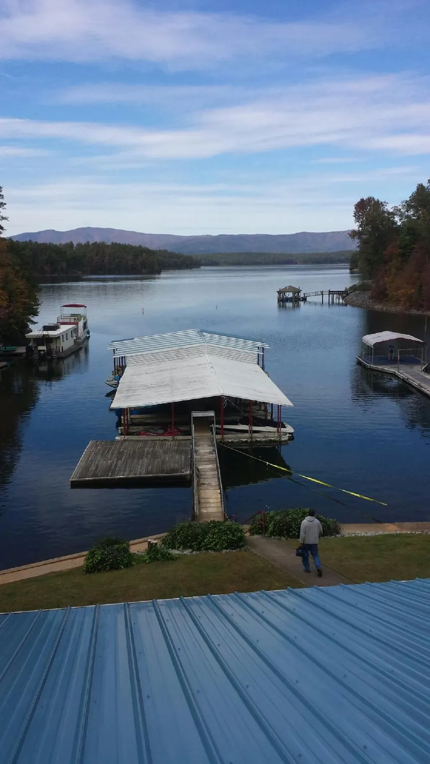 View across a lake from a newly installed blue metal roof in Heath Springs